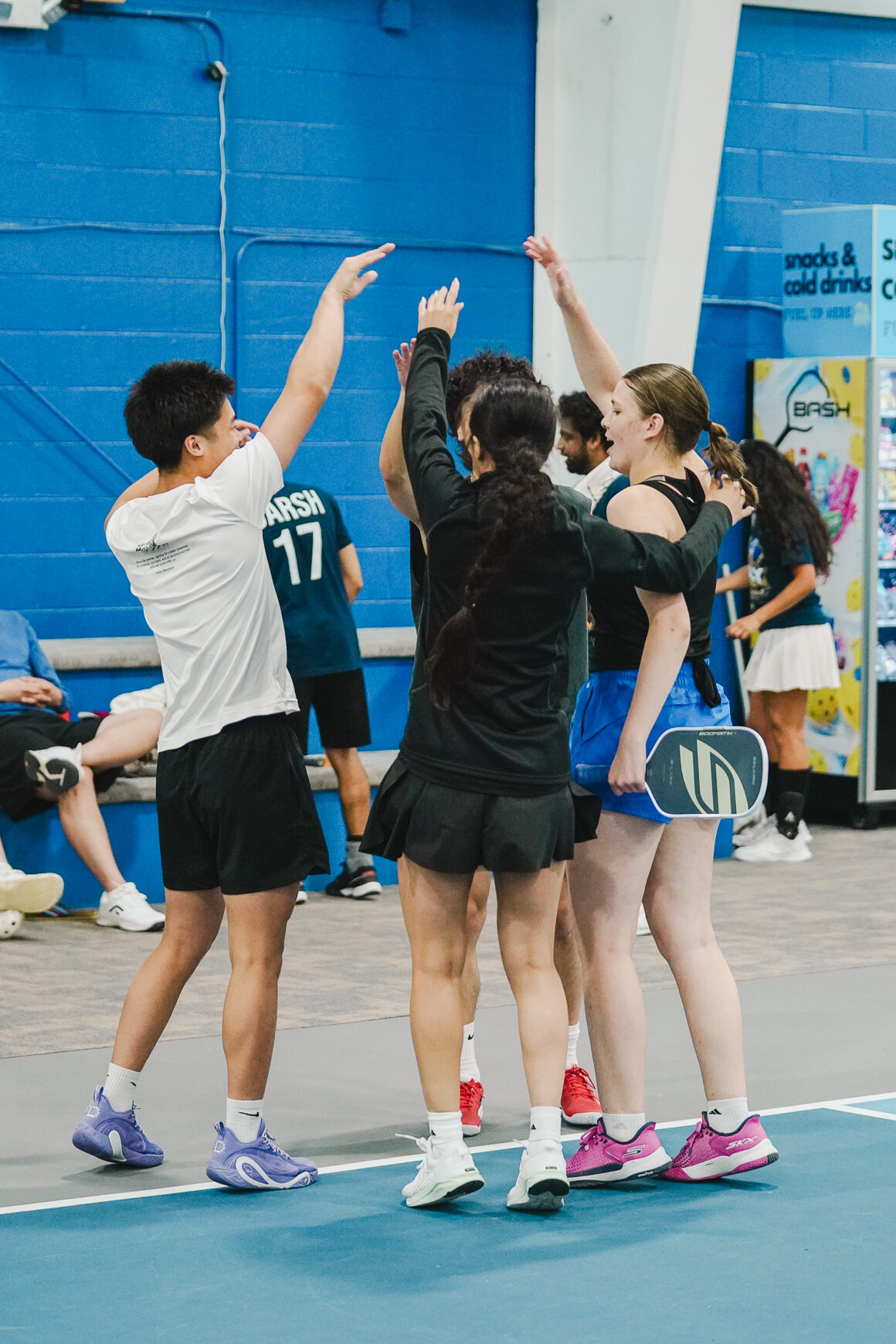League Match Point League teammates celebrating together during a team match at Bash Pickleball Club in Michigan.